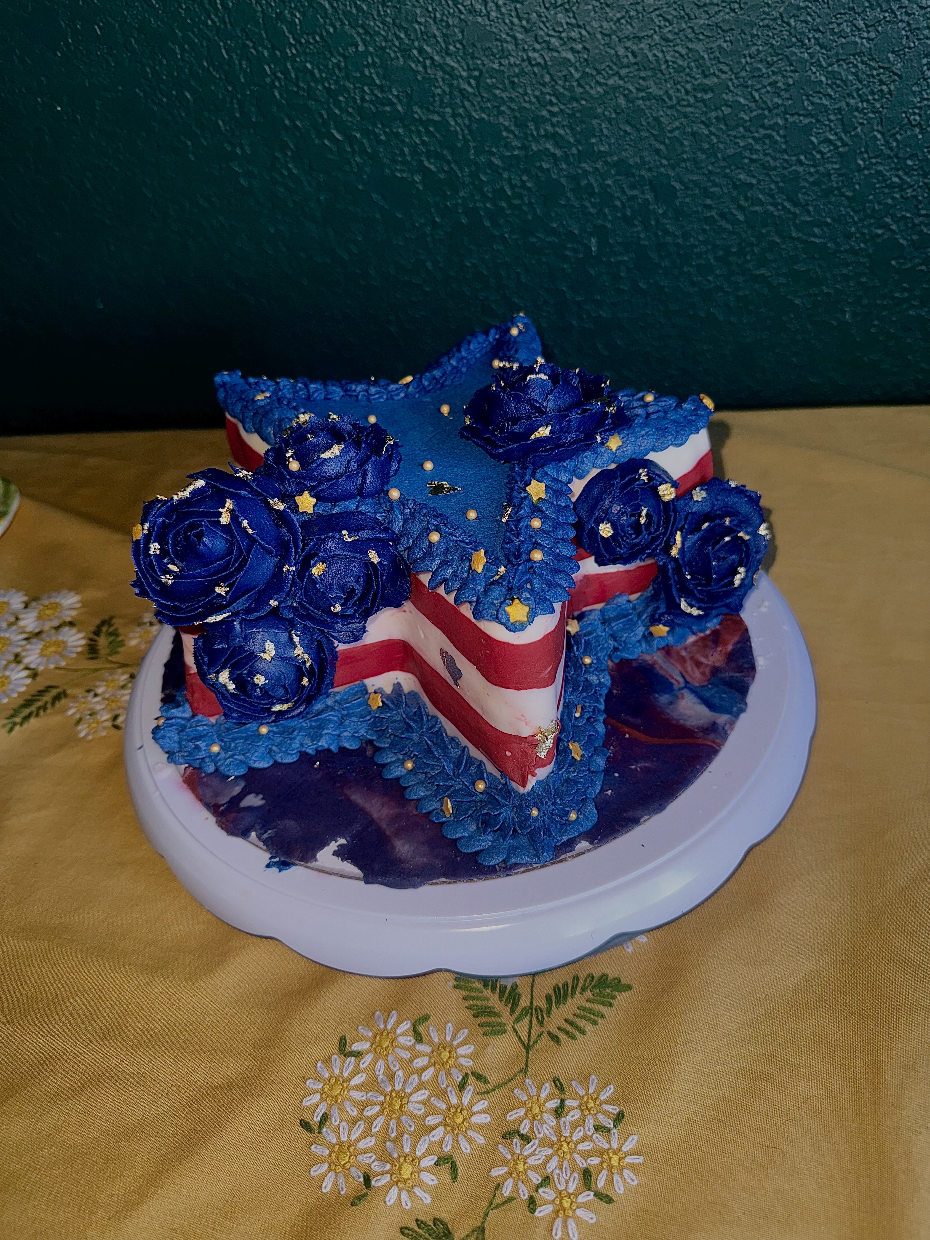 Star-shaped cake with buttercream roses and gold leaf